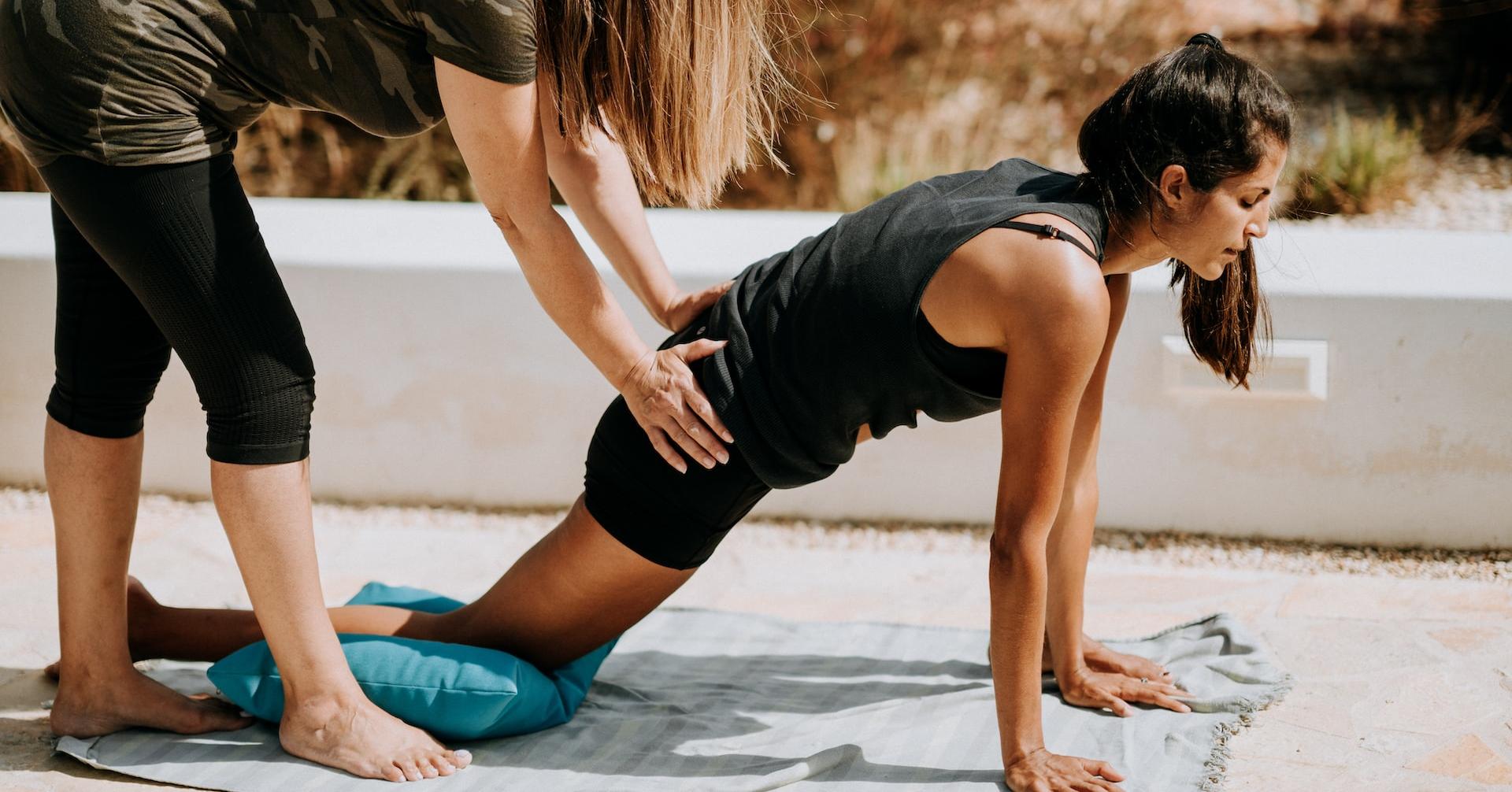 woman in black tank top and black shorts kneeling on mat